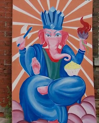A painting of the elephant-headed Hindu god Ganesha on the outside wall of a building.